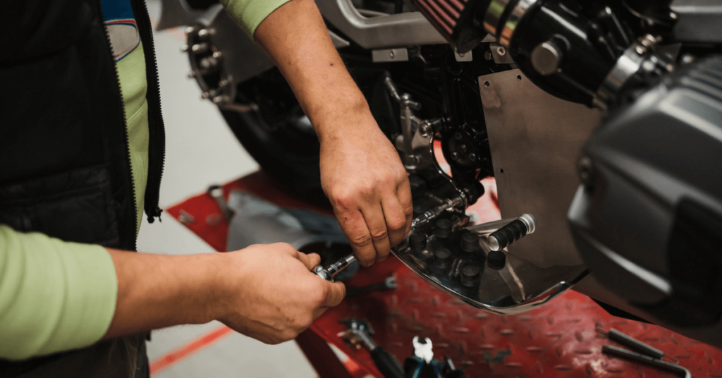 Persona realizando mantenimiento básico en una motocicleta con herramientas